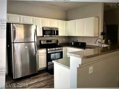 Kitchen featuring a sink, white cabinetry, a penin