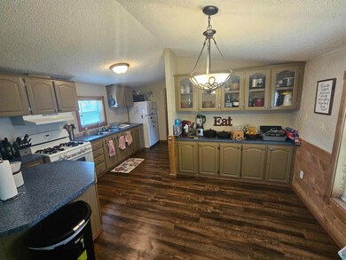 Kitchen featuring white appliances, a textured cei