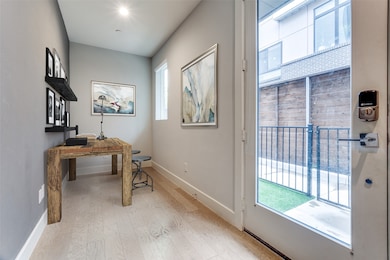 Entryway with wood finished floors and an office area