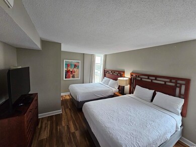 Bedroom with dark hardwood / wood-style floors and