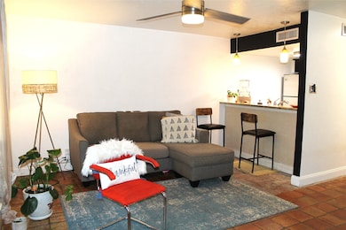 Living room with ceiling fan and baseboards