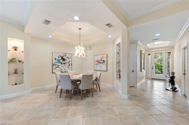 Dining area with ornamental molding, built in shelves, and a raised ceiling