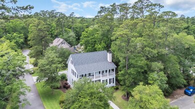 Aerial view of property and surrounding area with a forest