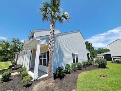 View of side of property featuring covered porch and a lawn