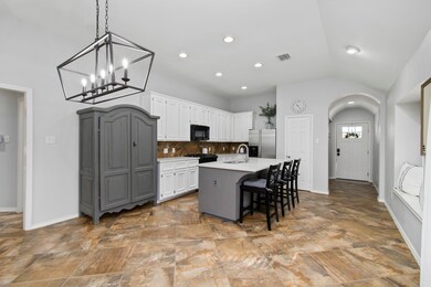 Gorgeous kitchen with recessed lighting and updated light fixture. Quarts counter tops, updated cabinets and bar seating!