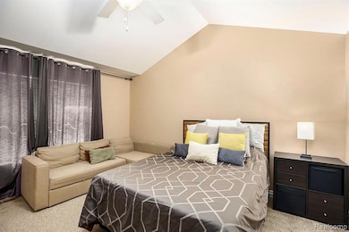 Carpeted bedroom with lofted ceiling and a ceiling fan