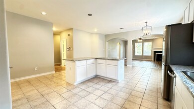 Kitchen with white cabinets, light stone countertops, a ceiling fan, recessed lighting, and arched walkways