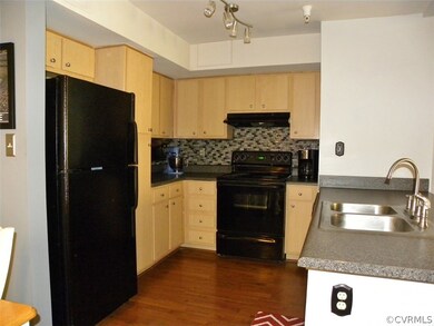 Kitchen with laminate floor, glass tile backsplash