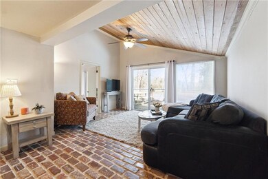 Living room with brick floor, ceiling fan, wooden 