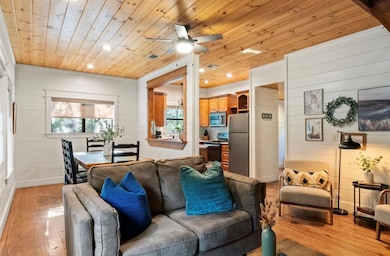 Living room featuring light wood-type flooring, wood walls, recessed lighting, wood ceiling, and ceiling fan