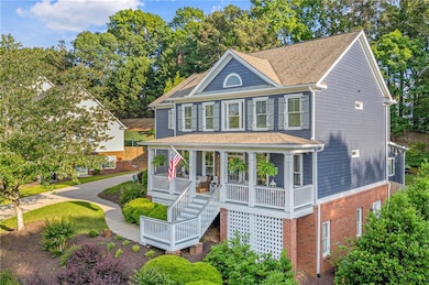 View of front of home with a porch, roof with shingles, and brick siding