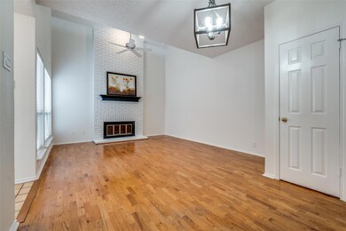 Unfurnished living room featuring a brick fireplac