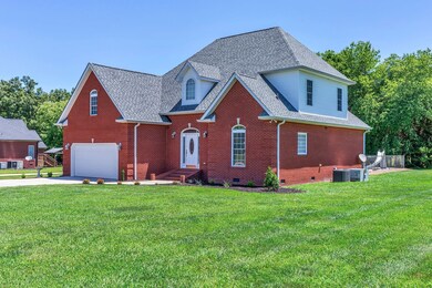 Brick home and garage situated on large, level yard of almost an acre!