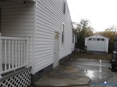View of home's exterior featuring crawl space, an outdoor structure, and a detached garage