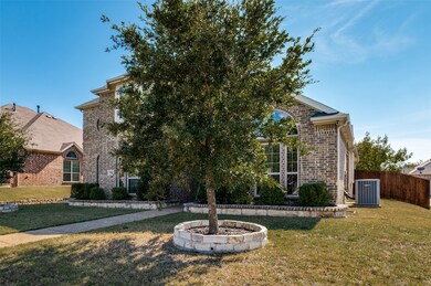 View of property hidden behind natural elements with brick siding