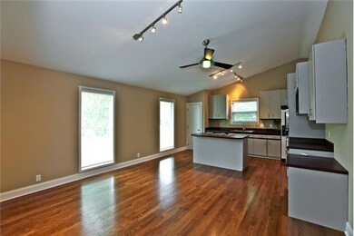 Huge eat-in kitchen has hardwood floors and an island