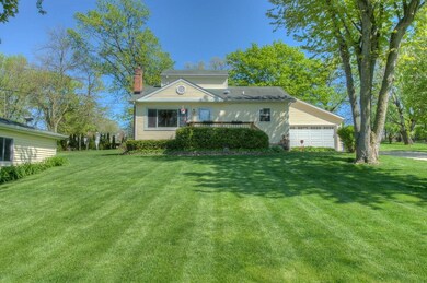 FRONT OF THE HOUSE WITH ATTACHED GARAGE WITH EXPANSIVE FRONT YARD