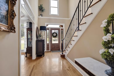 Entrance foyer with a high ceiling, light hardwood