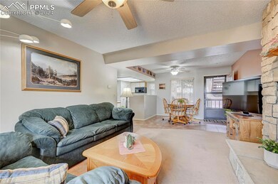 Carpeted living room featuring a stone fireplace, 