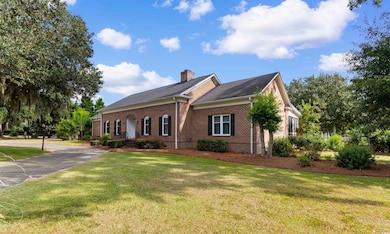 View of front of home with a front yard, brick siding, a chimney, crawl space, and roof with shingles