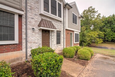 View of exterior entry with brick siding and a wa