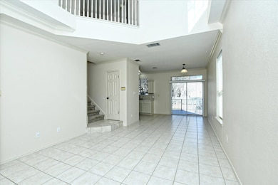 Spare room featuring light tile patterned floors, crown molding, stairway, and a towering ceiling
