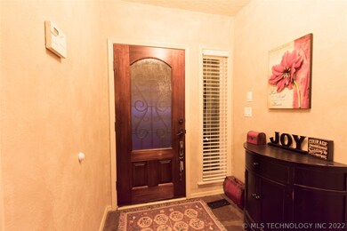 Open foyer with beautiful wood and iron front door