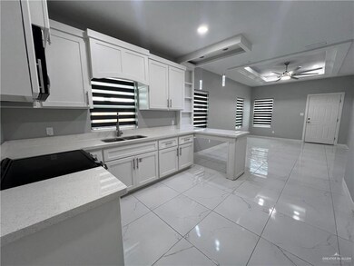 Kitchen with ceiling fan, light marble finish flooring, black / electric stove, and white cabinetry