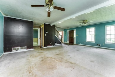 Spare room with a ceiling fan, baseboards, a textured ceiling, and carpet floors