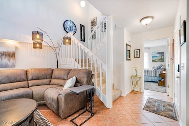 Living area featuring light tile patterned flooring and stairs