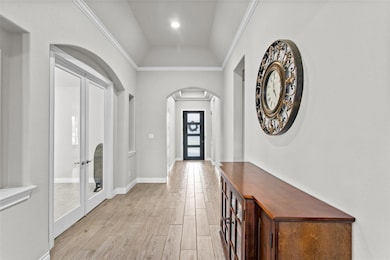 Entryway featuring arched walkways, light wood-st