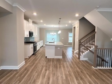 Kitchen featuring white cabinets, an inviting chan