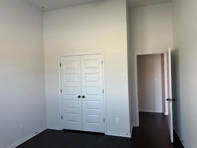 Unfurnished bedroom with a closet and dark wood-t