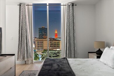 Bedroom featuring wood finished floors, expansive windows, and a city view