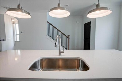 Kitchen featuring pendant lighting and light stone countertops