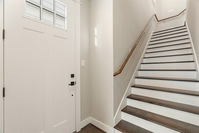 Step through the grand entrance, offering access to the staircase, garage, and a private bedroom.