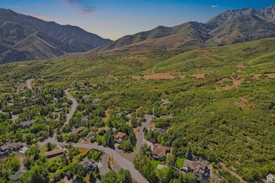 Aerial view of property and surrounding area featuring a mountain backdrop