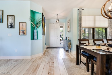Foyer entrance with an inviting chandelier, baseboards, and hardwood / wood-style flooring