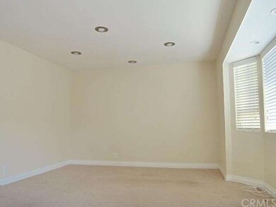 Living room with recessed lighting.  New carpet will be installed soon.