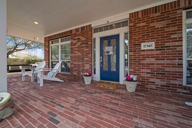 Lovely, large, covered, brick front porch with swing, plus front door with sidelights and transom!