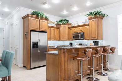 Kitchen with ornamental molding, appliances with stainless steel finishes, backsplash, and dark stone counters