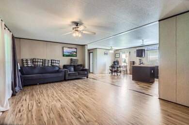 Living area featuring ceiling fan, light wood-sty
