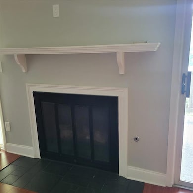 Detailed view of a glass covered fireplace and wood finished floors