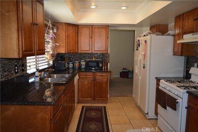Kitchen with granite countertops and glass tile back splash.