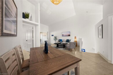 Dining room with high vaulted ceiling and light ti