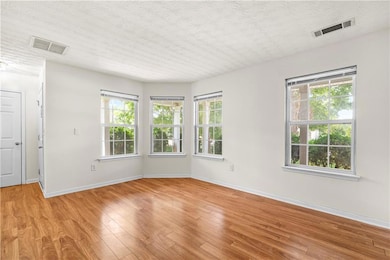 Unfurnished room with wood finished floors and baseboards