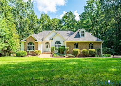 View of front facade with roof with shingles, brick siding, and a front lawn