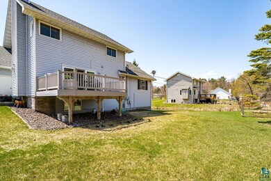 Back of property with a wooden deck, a yard, and a