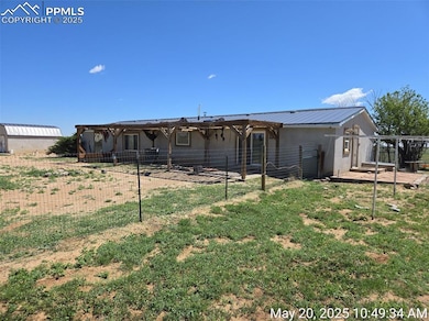 Back of house with stucco siding, metal roof, and a patio area