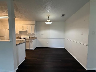 Kitchen featuring white appliances, dark wood-sty